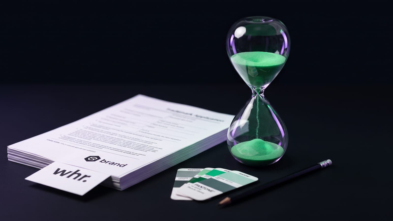 Reloj de arena con arena verde cayendo junto a una pila de documentos de solicitud y muestras Pantone: los plazos reales de cuánto tarda el registro de marca en el IMPI