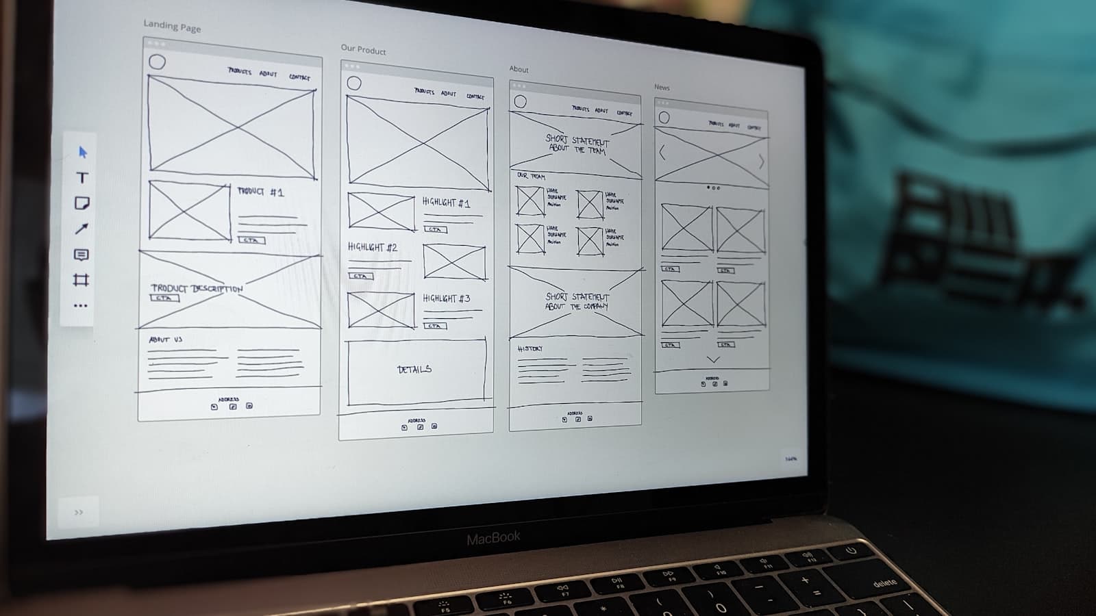 Boceto de una landing page en la pantalla de una laptop sobre un escritorio de oficina