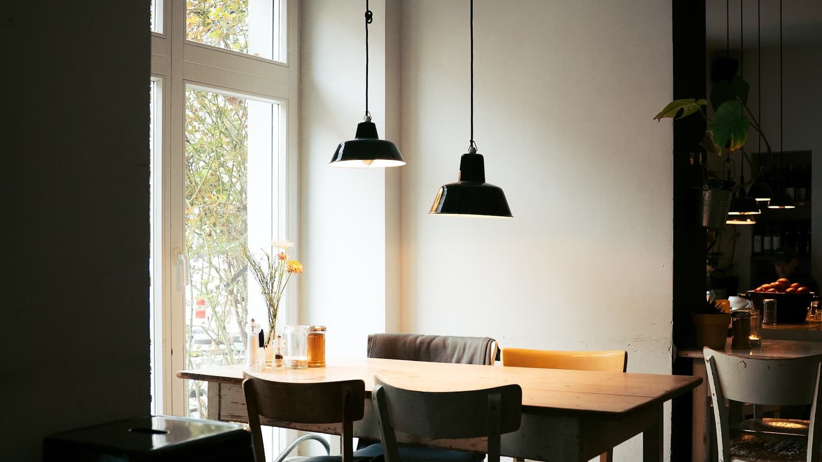 Interior de un restaurante con mesas y sillas junto a la ventana que refleja la identidad de marca del local