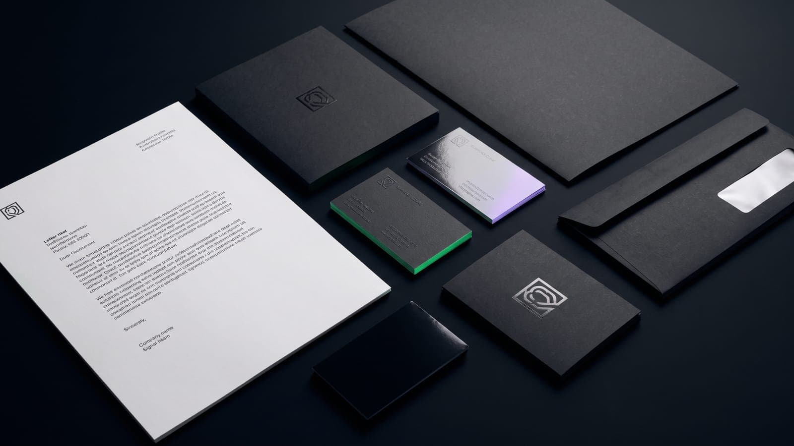 Papelería de marca en cenital: hoja membretada, sobres negros con logo en foil y tarjetas con cantos verde y violeta, el sistema completo detrás de cuánto cuesta el branding en México