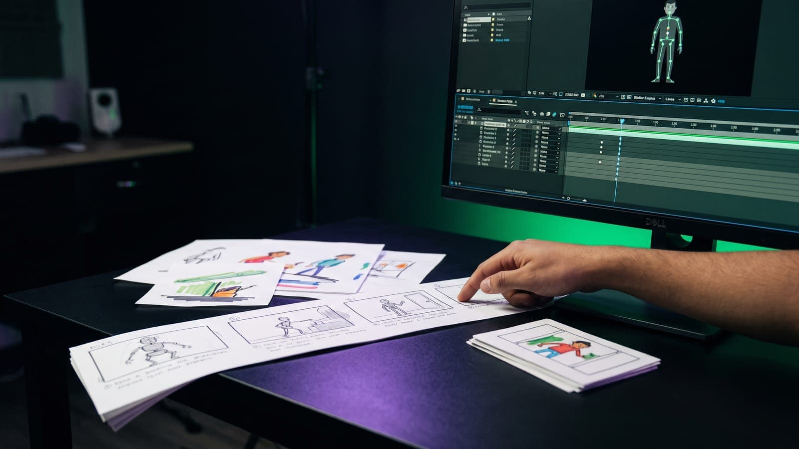 Mano señalando frames de un storyboard con personajes de caricatura, junto a un monitor con un personaje riggeado y timeline de animación, al cotizar cuánto cuesta un spot o video animado en México