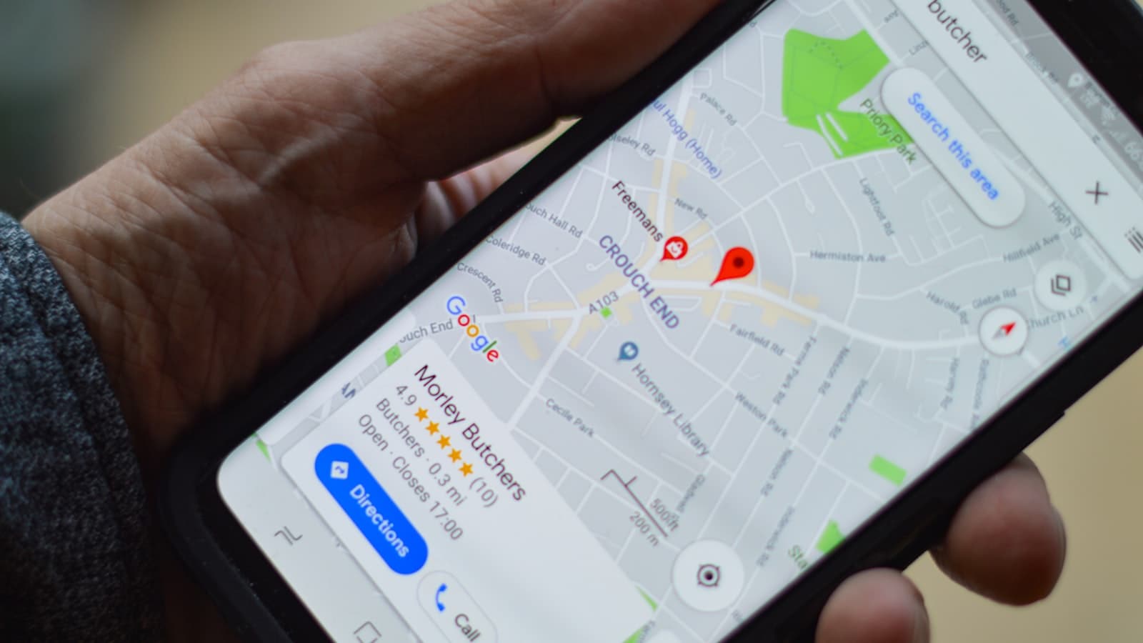 Persona sostiene un teléfono con un mapa de ubicación local, ideal para optimizar el perfil de Google Mi Negocio