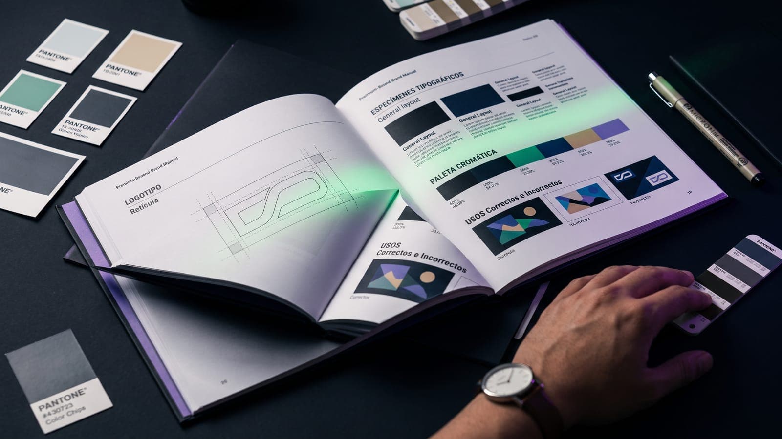 Manual de marca premium abierto en las páginas de retícula del logotipo, especímenes tipográficos, paleta cromática y usos correctos e incorrectos