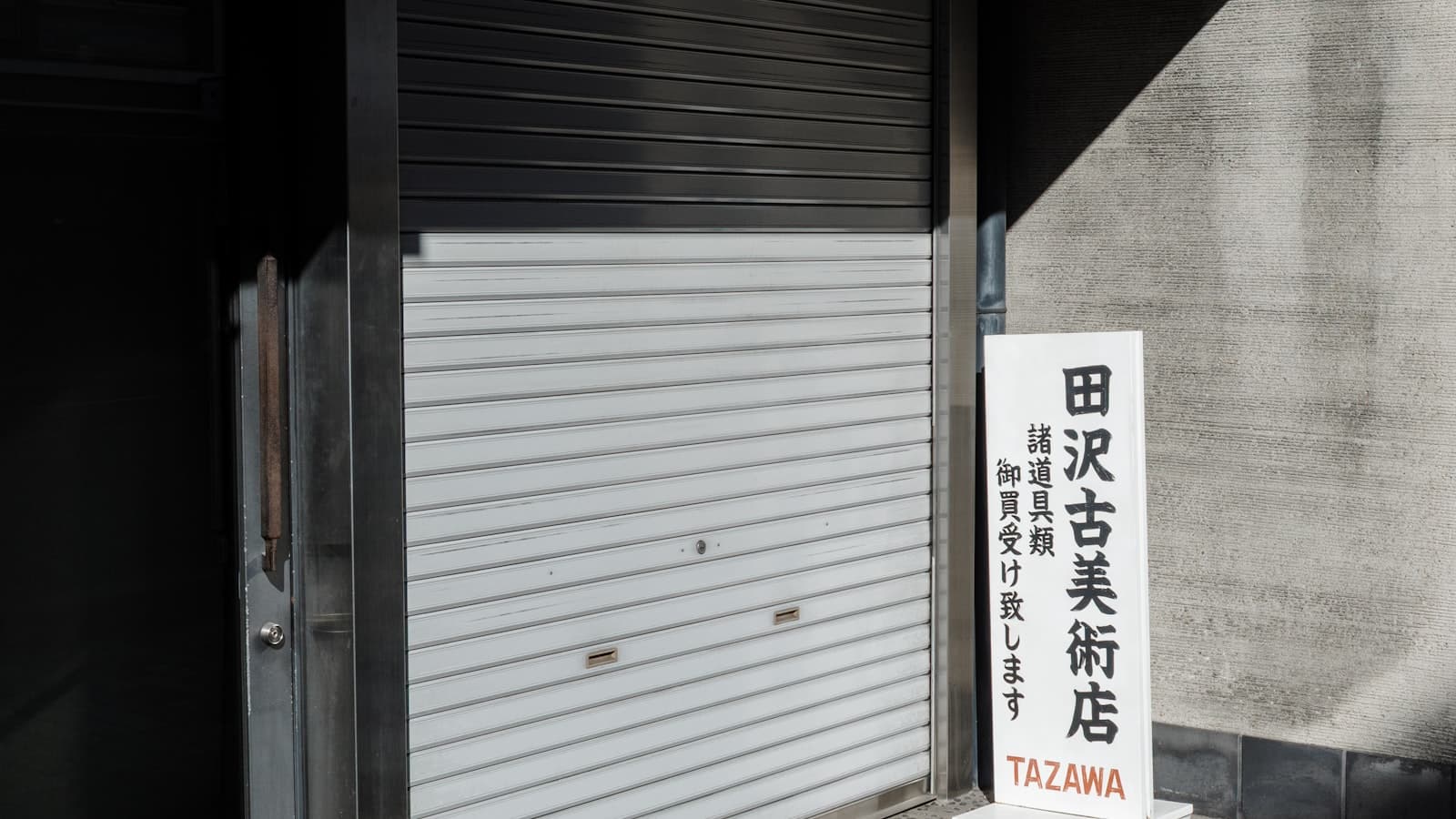 Local comercial con cortinas metálicas cerradas en la calle, símbolo de un negocio que no genera ventas