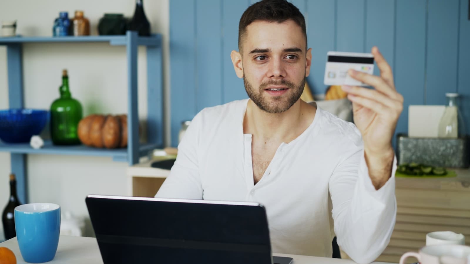 Persona con tarjeta de crédito frente a una laptop completando una compra en una página web que sí convierte