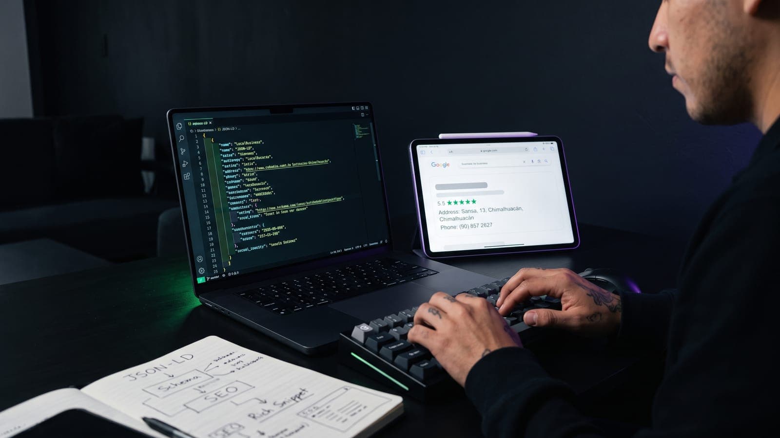 Laptop con código JSON-LD de datos estructurados junto a una tablet mostrando un rich snippet con estrellas en Google: schema markup aplicado a negocios