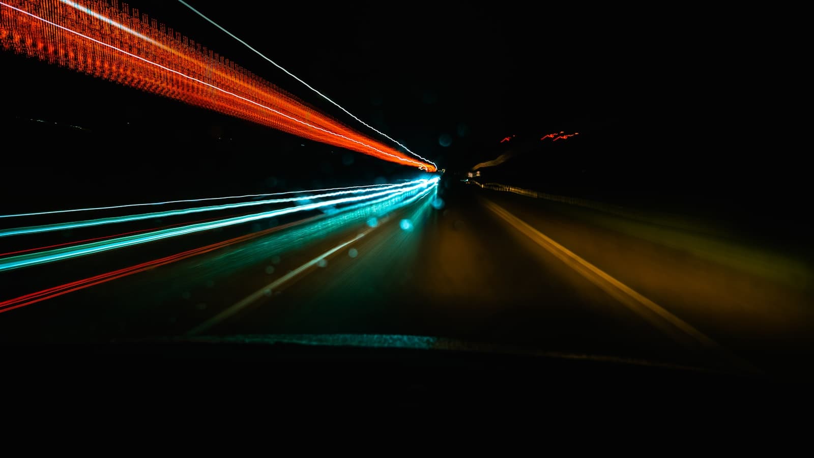 Estelas de luz de vehículos en movimiento por la noche que evocan la velocidad de carga de un sitio web